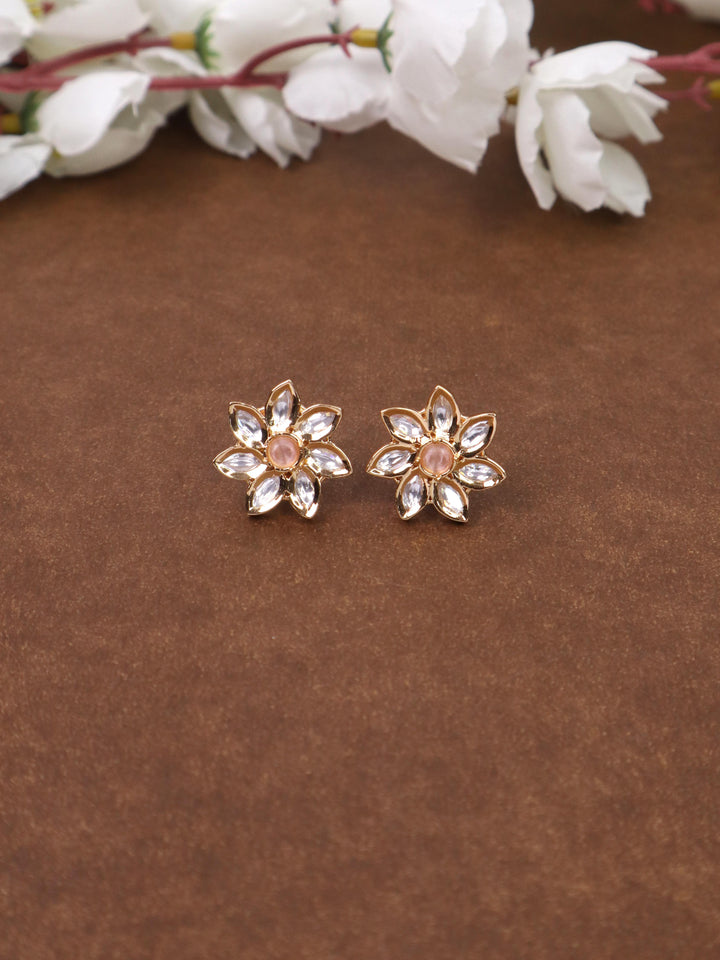 A closeup image of Zara Kundan Polki Pink Stud Earrings by Live Some India on a brown background 