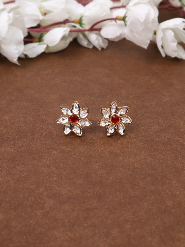 A closeup image of Zara Kundan Polki Red Stud Earrings by Live Some India on a brown background 