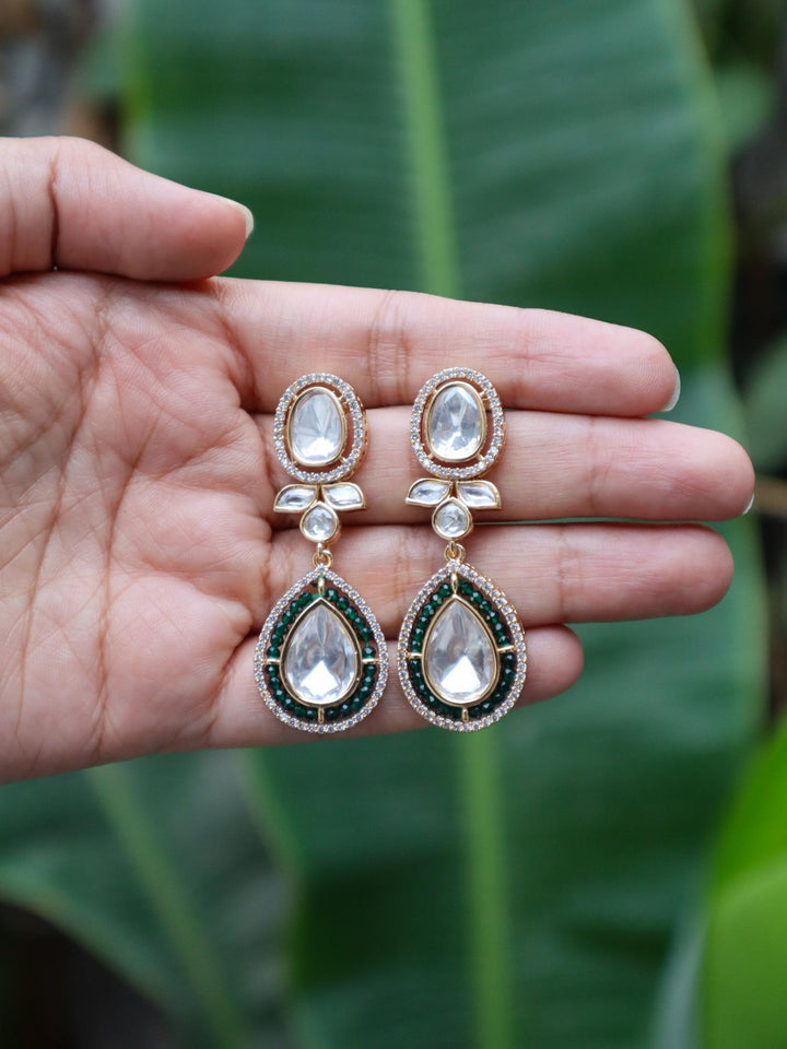 Zavi Kundan Polki Dangle Earrings by Live Some India on hands with natural eaves background