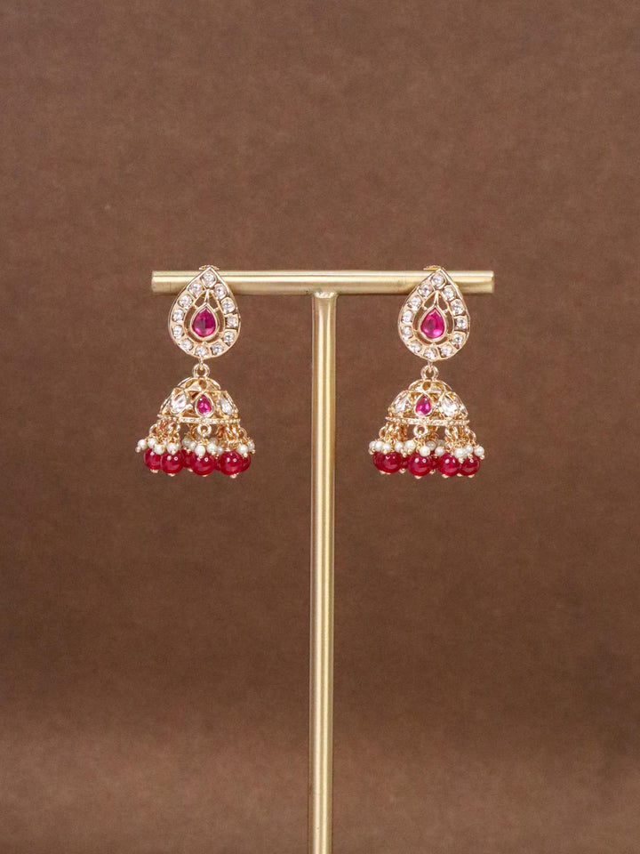 Anika Small Kundan Polki Jhumka Earrings - by Live Some India in just Anika Small Kundan Polki Red Jhumka Earrings by Live Some India on an earring stand with brown background