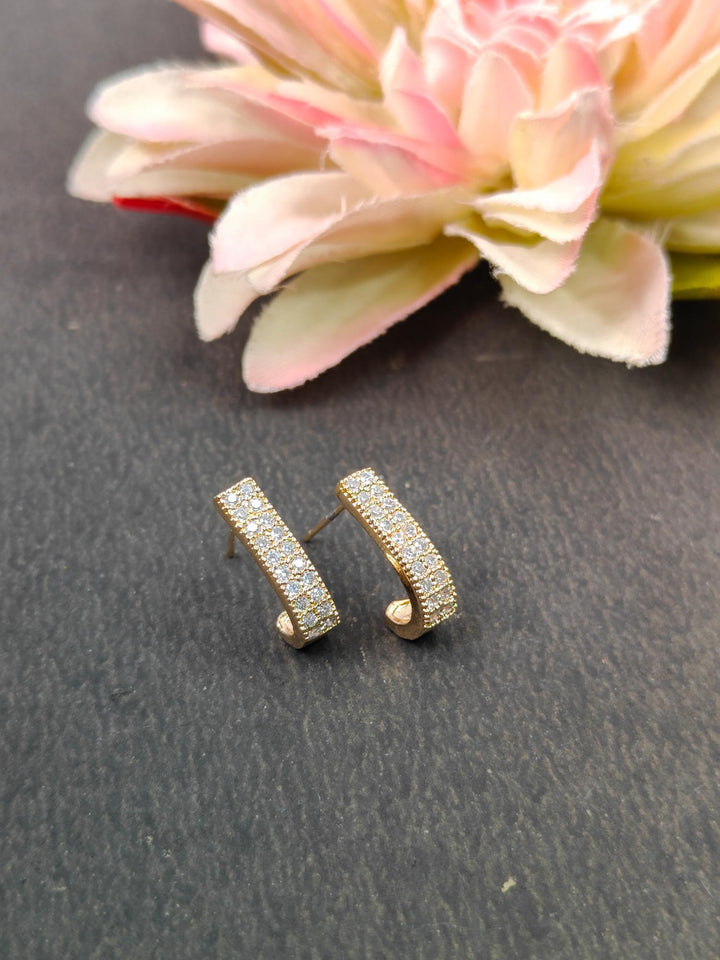 Dainty Statement Earrings - by Live Some India in just A closeup image of Gold Dainty Statement Earrings by Live Some India on a grey background with flower