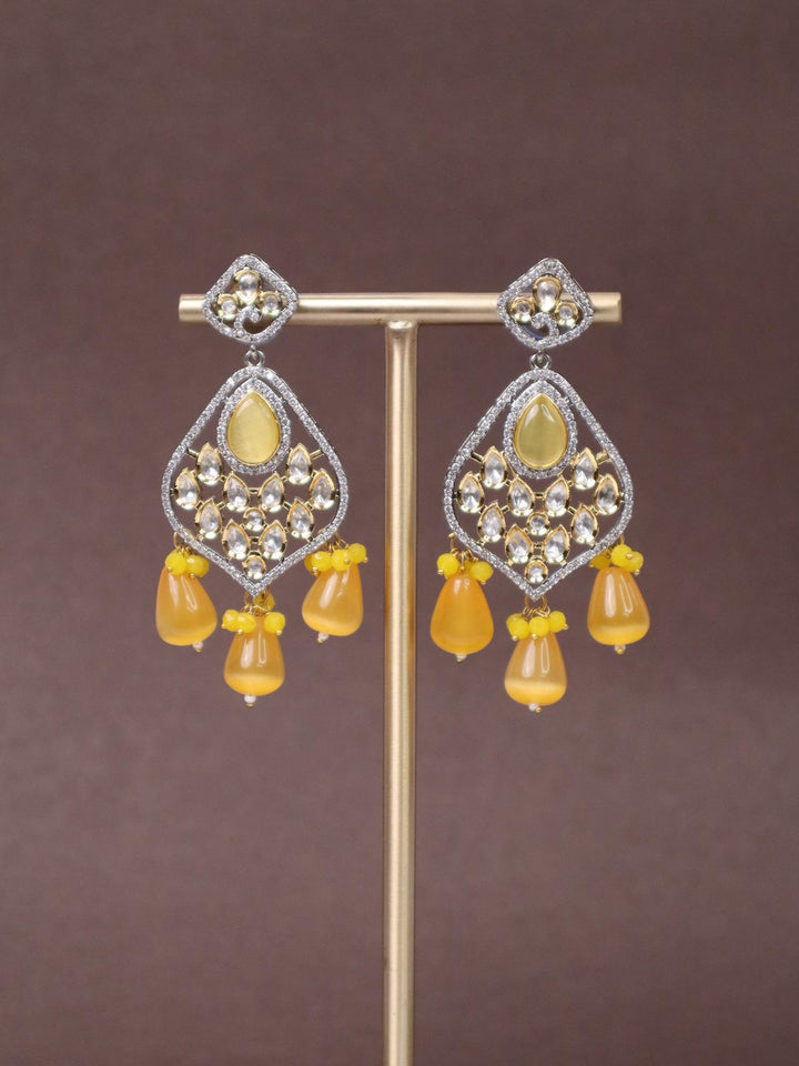 Dakshya Kundan Polki Dangler Earrings - by Live Some India in just A closeup image of Dakshya Yellow Kundan Polki Dangler Earrings by Live Some India on a brown background