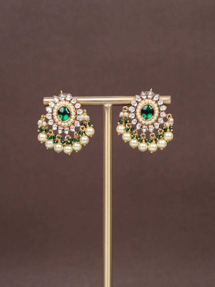 Heer Kundan Polki Dangler Earrings - by Live Some India in just A closeup image of Heer Green Kundan Polki Dangler Earrings by Live Some India on a brown background