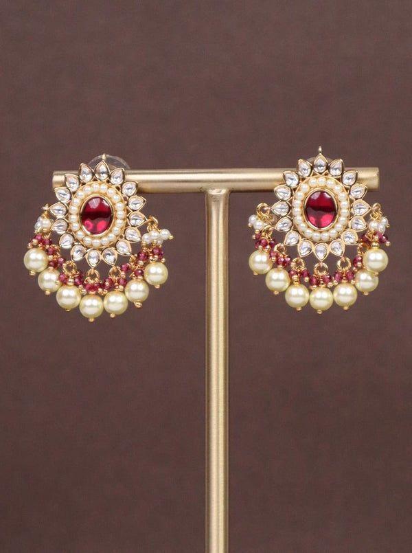 Heer Kundan Polki Dangler Earrings - by Live Some India in just A closeup image of Heer Red Kundan Polki Dangler Earrings by Live Some India on a brown background